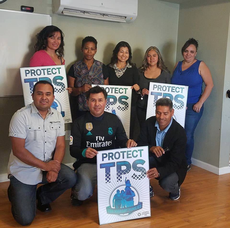 People holding Protect TPS poster